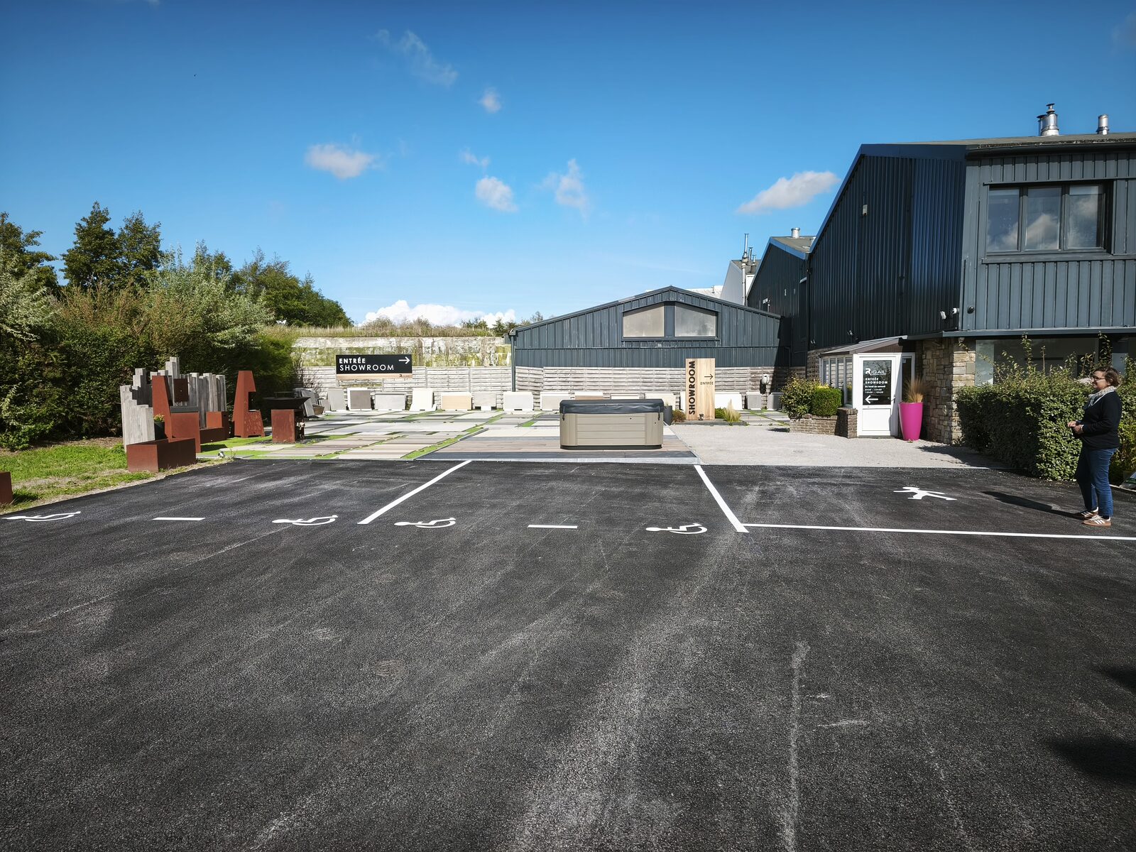 Signalétique extérieure du showroom Rigail à Saint-Martin-Boulogne : totem d'accueil et panneau « Entrée showroom » visibles depuis le parking